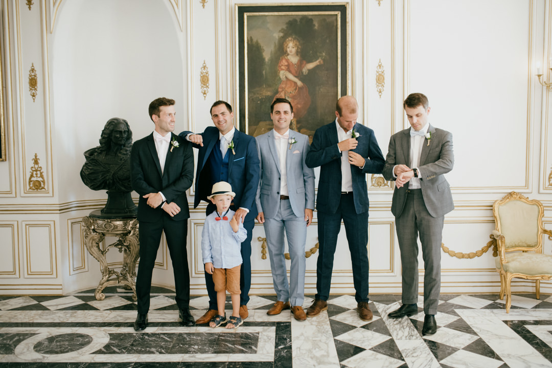 groomsmen in suits in large marble room