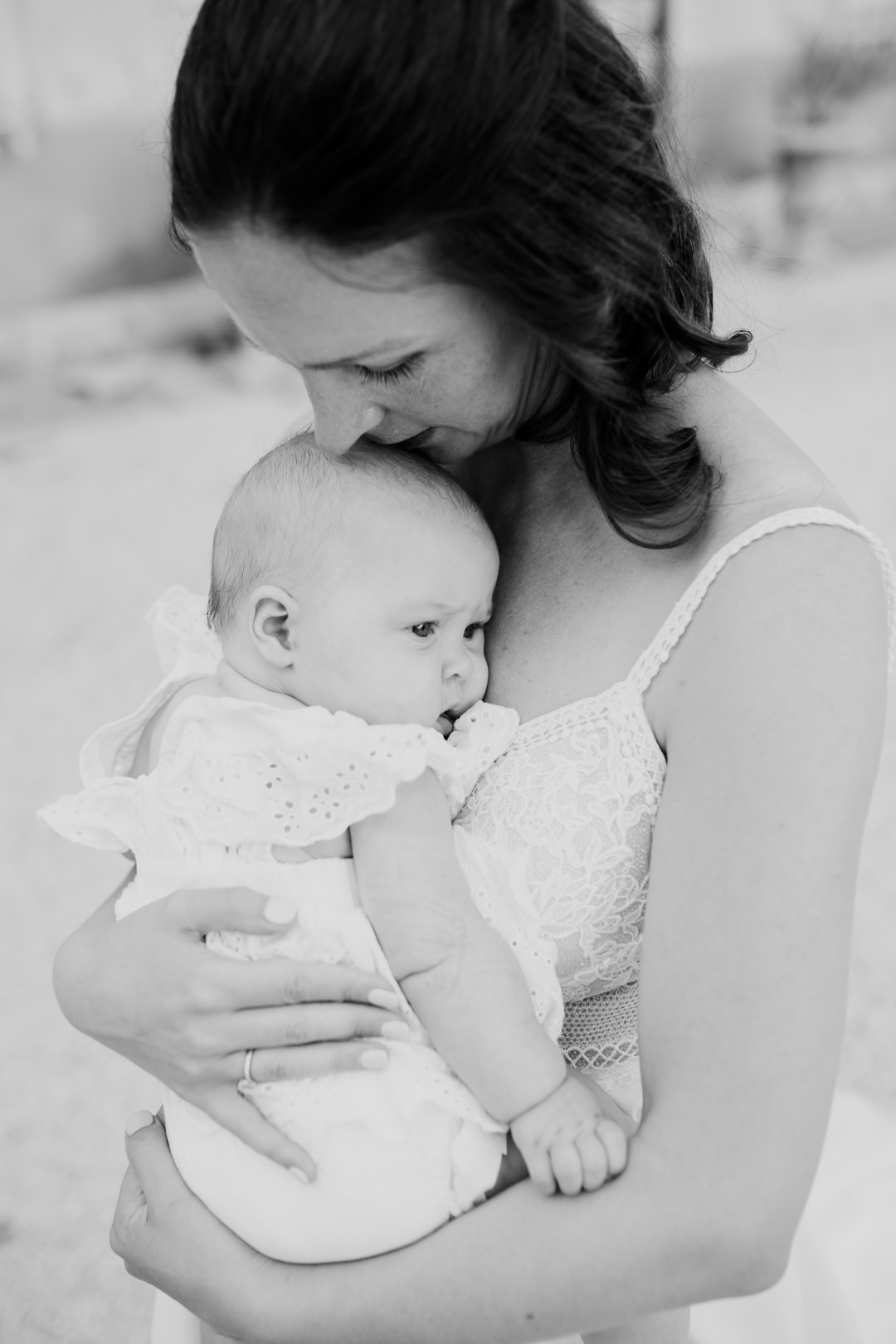 bride in white dress holding small baby