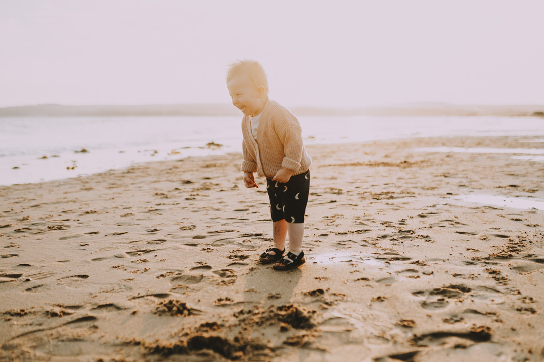 small boy playing in sand on beach