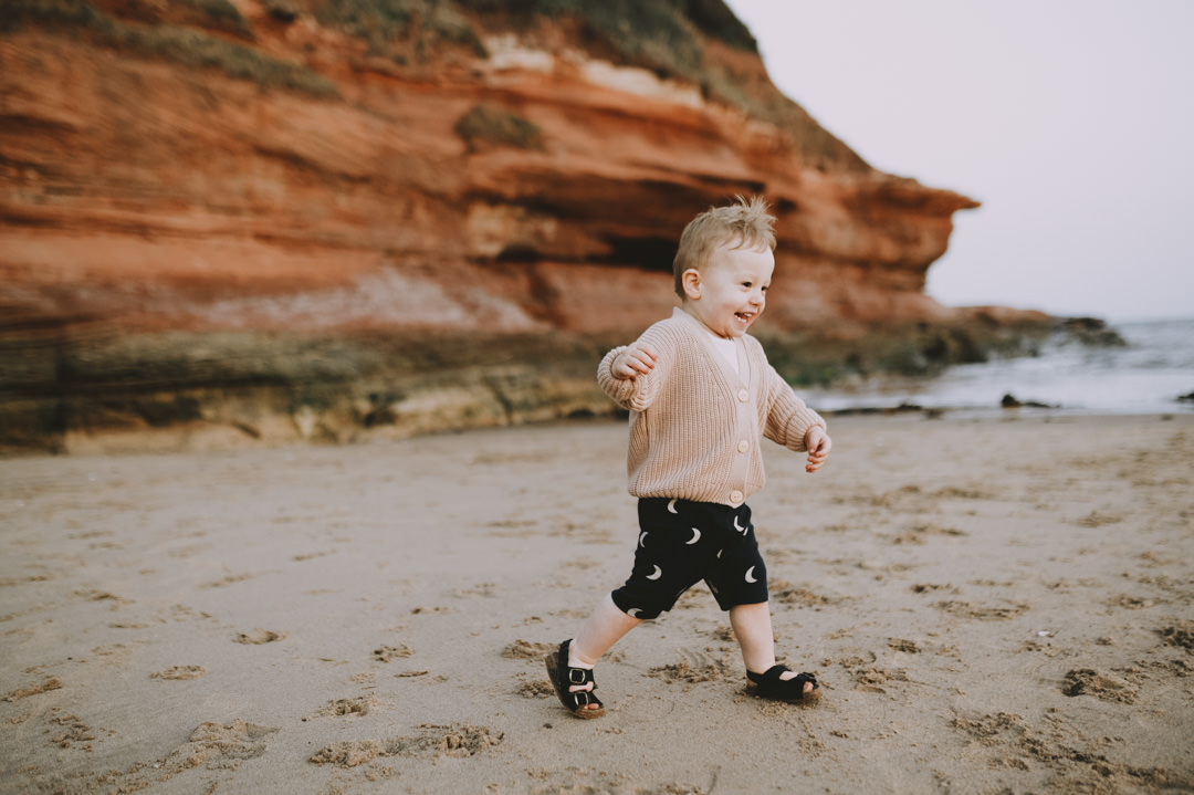 small boy running on sandy beach in Devon