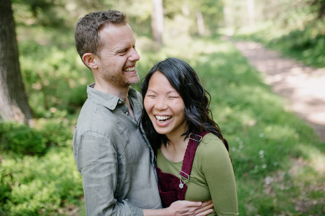 man and woman smiling and embracing in forrest during day time