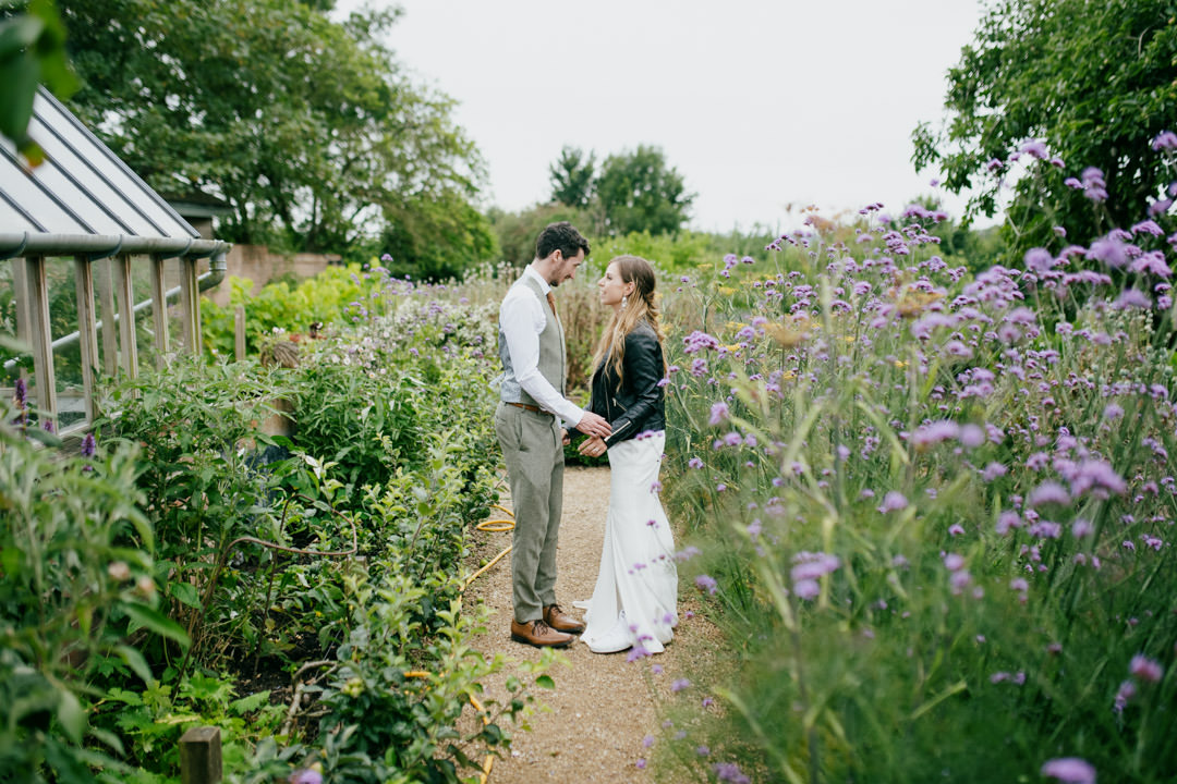 bride and groom stood in floral garden