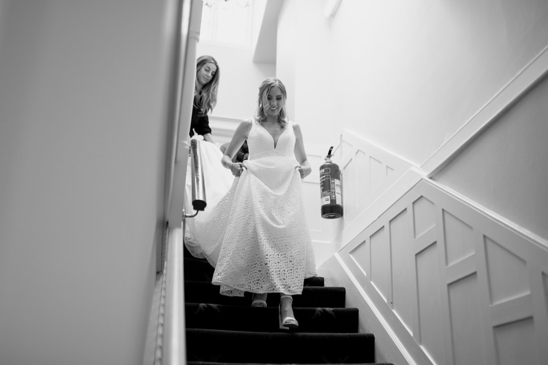 bride walking down stairs in white dress