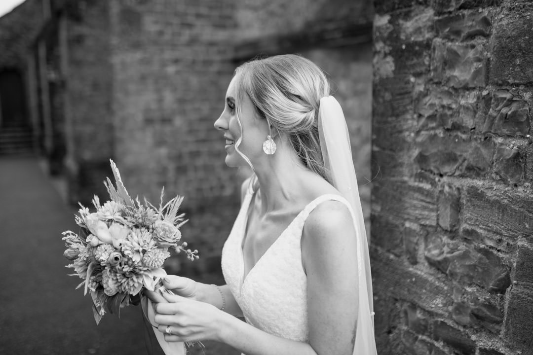 bride holding flowers outside church