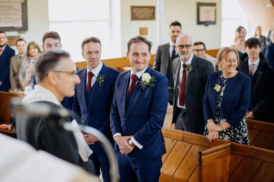 groom waring blue suit in church during daytime