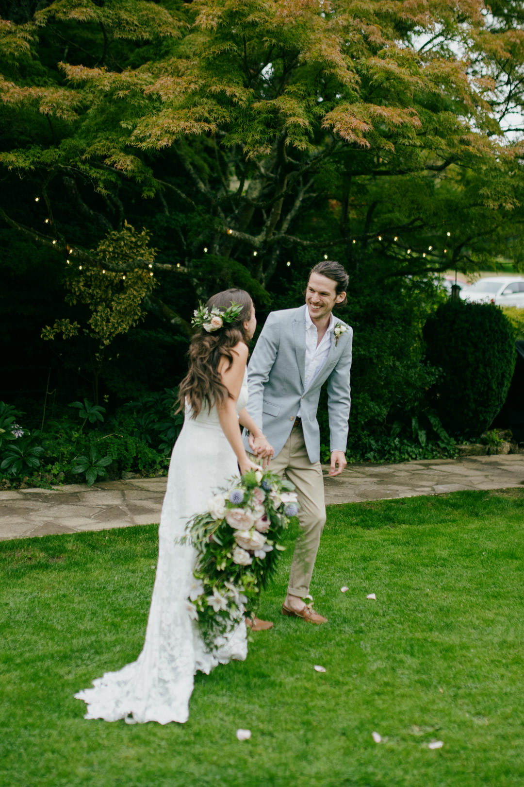 bride waring flower crown in garden with large trees