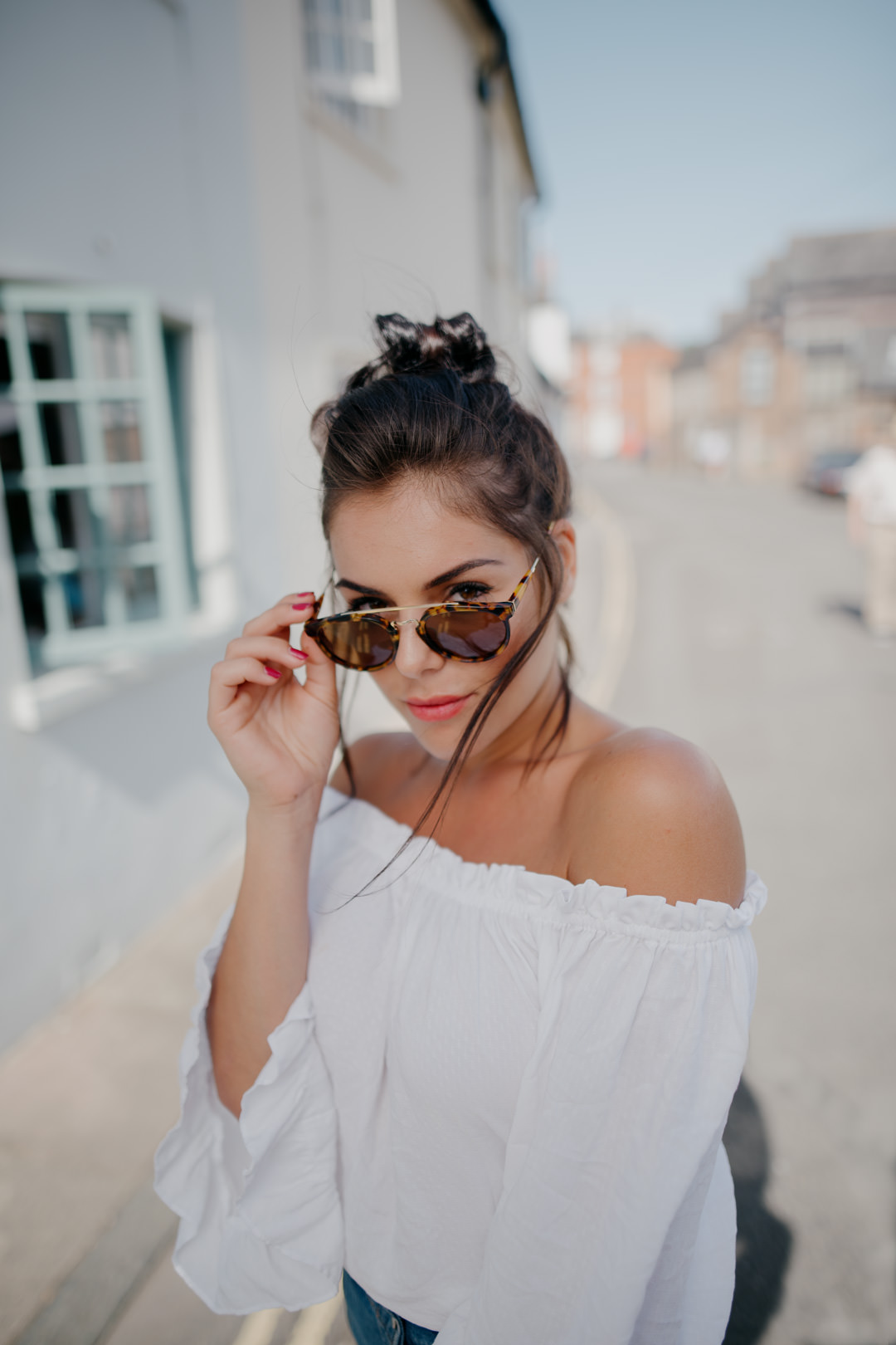 girl waring sun glasses in urban street smiling
