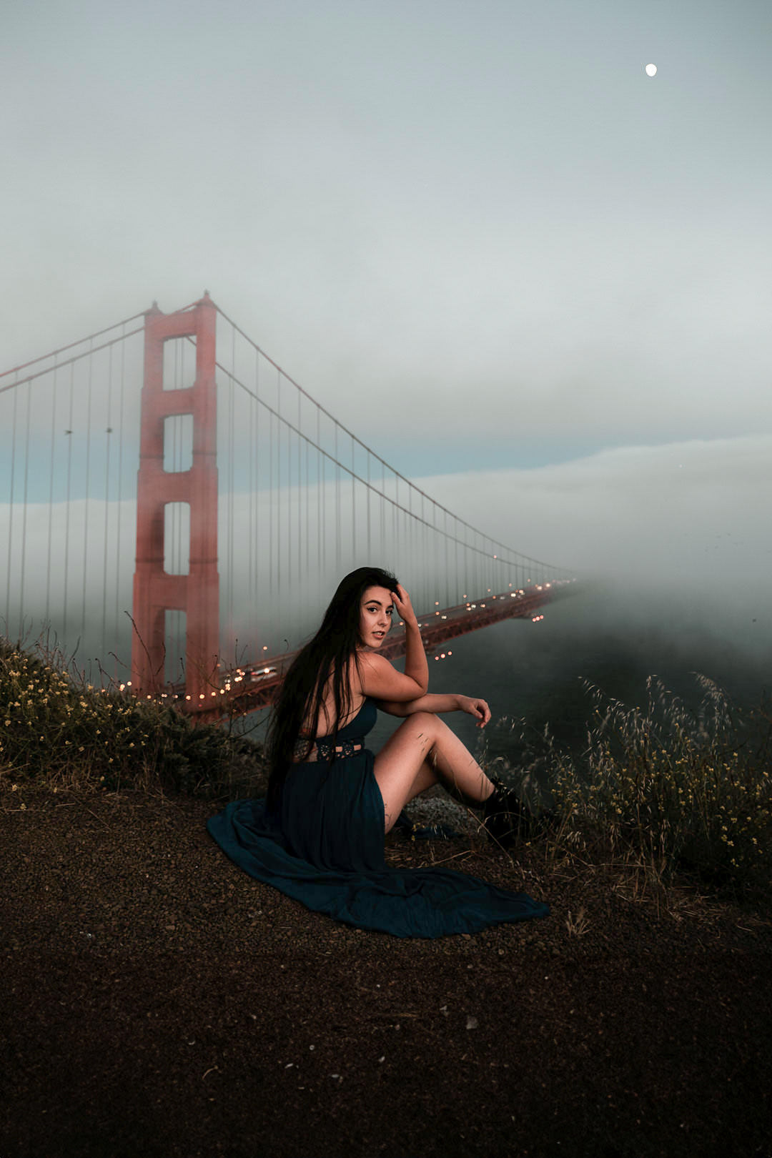 girl waring black dress with golden gat bridge behind in fog