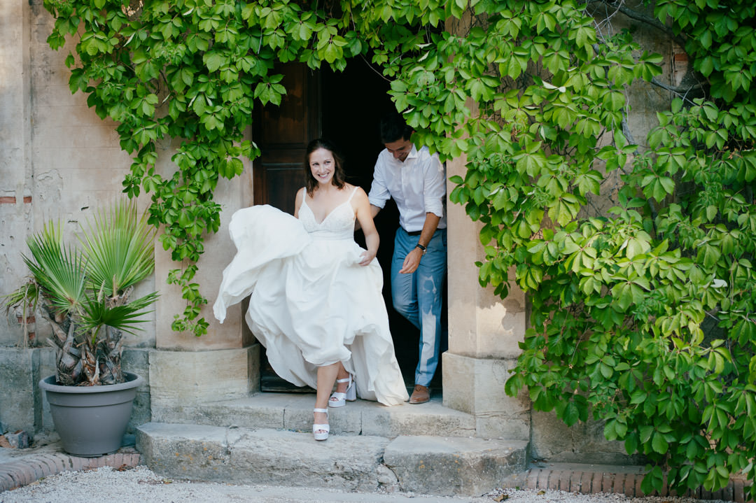 bride and groom walking out of castle doors into large garden
